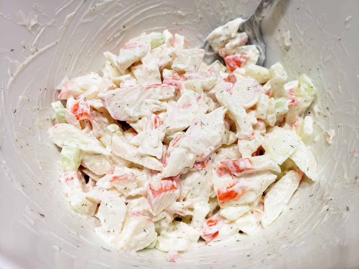 a bowl filled with imitation crab meat salad mixed together.