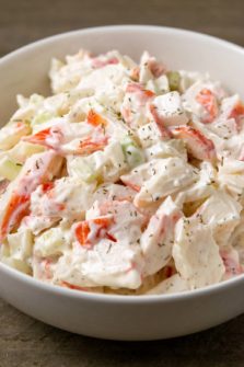 a bowl of small batch seafood salad with chopped imitation crab meat combined with onion and celery in a creamy mayonnaise dressing.
