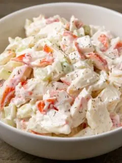 a bowl of small batch seafood salad with chopped imitation crab meat combined with onion and celery in a creamy mayonnaise dressing.
