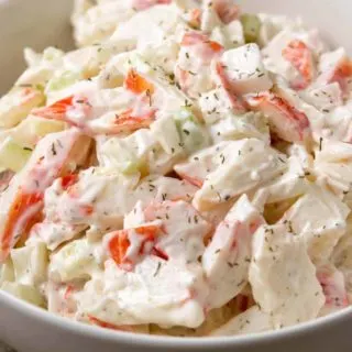 a bowl of small batch seafood salad with chopped imitation crab meat combined with onion and celery in a creamy mayonnaise dressing.