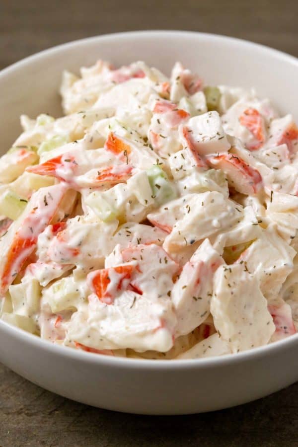 a bowl of small batch seafood salad with chopped imitation crab meat combined with onion and celery in a creamy mayonnaise dressing.