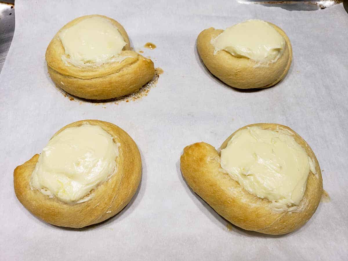 four baked cream cheese danishes on a baking sheet