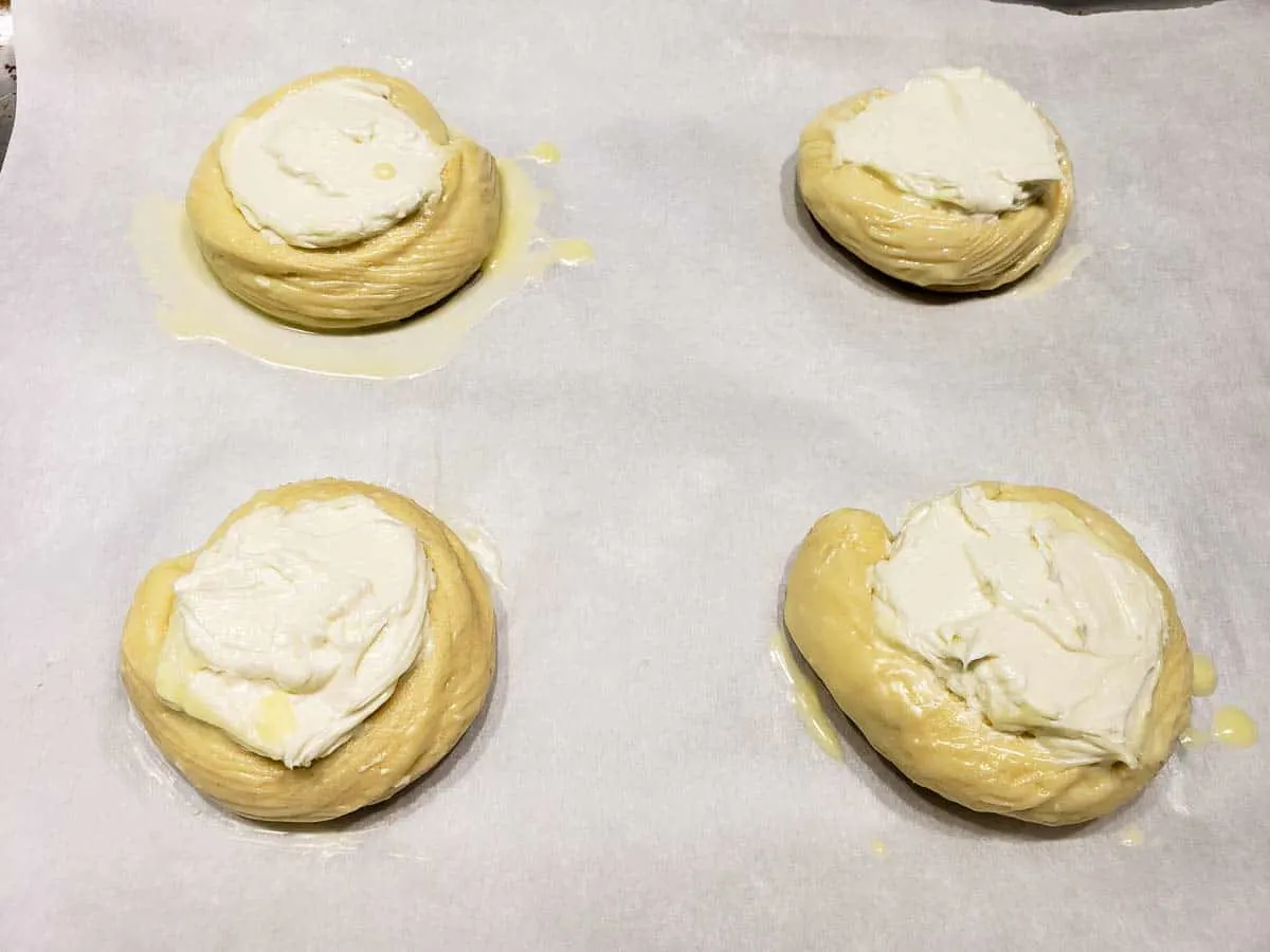 four crescent dough circles brushed with melted butter and filled with cream cheese filling
