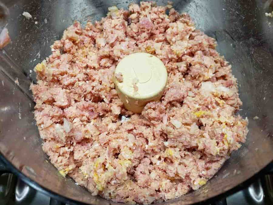 a food processor filled with finely chopped ham salad