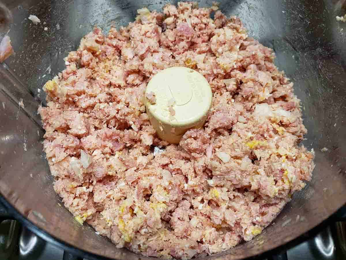 a food processor filled with finely chopped ham salad