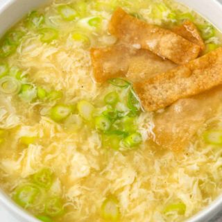 a bowl of egg drop soup topped with crispy wonton croutons.