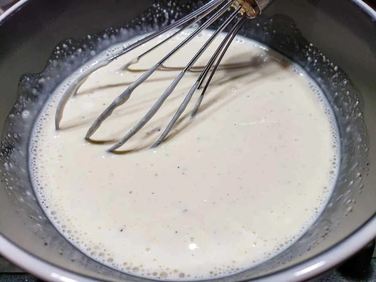 a bowl filled with mayo, milk, brown sugar, salt and pepper whisked together.