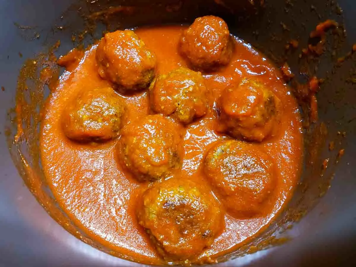 meatballs and red spaghetti sauce in a pan.