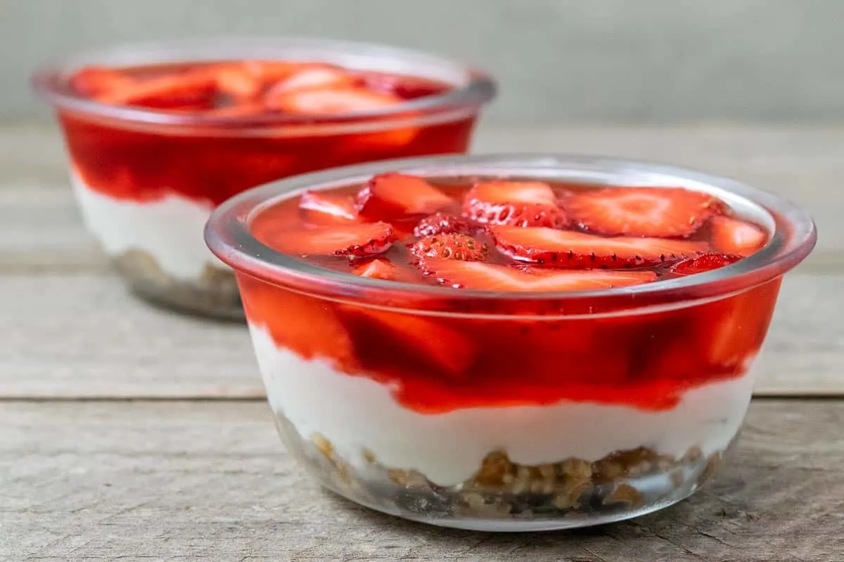 two bowls filled with strawberry pretzel dessert in two bowls.