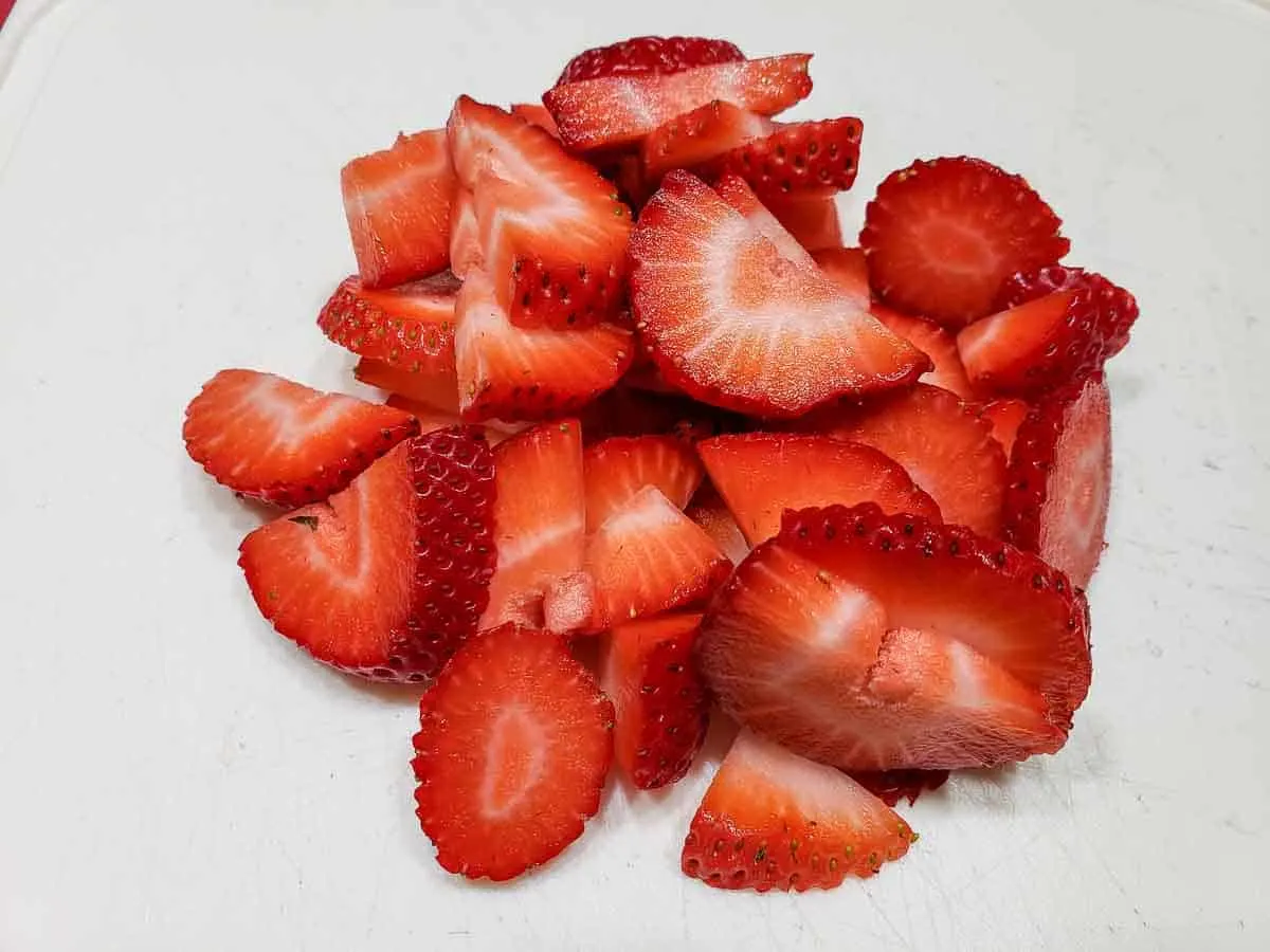 sliced strawberries on a cutting board.