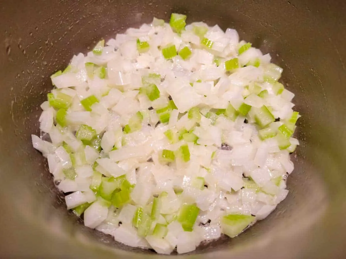 celery and onions cooking in a pan.