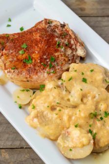 a plate filled with a Crock Pot Pork Chop and Au Gratin Potatoes.