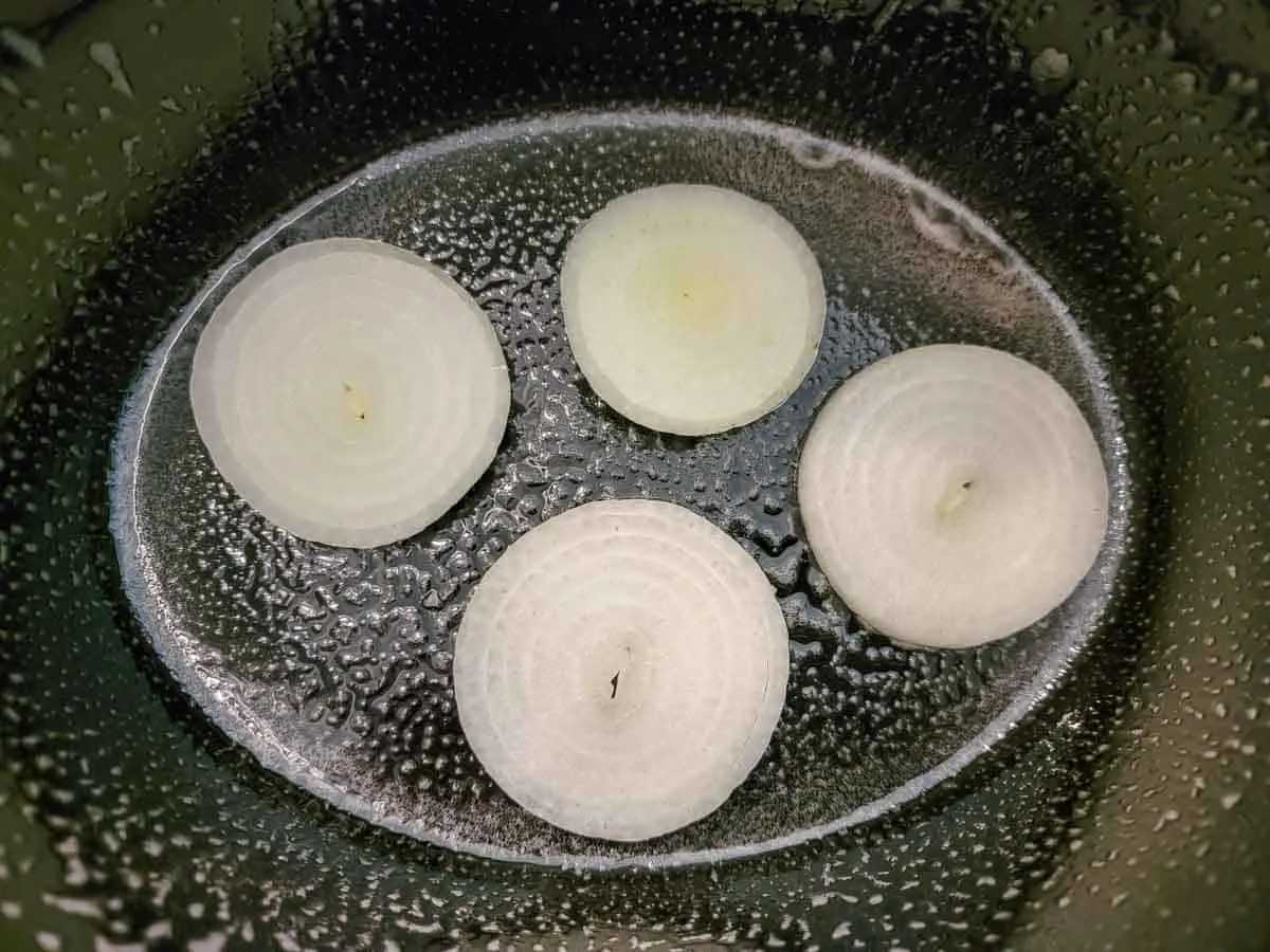 sliced onions in a crock pot.