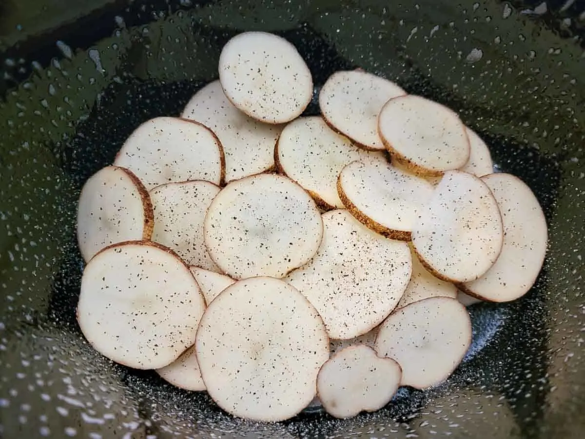 sliced potatoes in a crock pot.