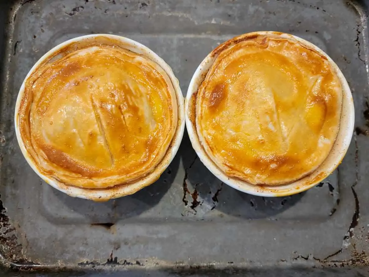 two baked mini pies on a baking sheet.