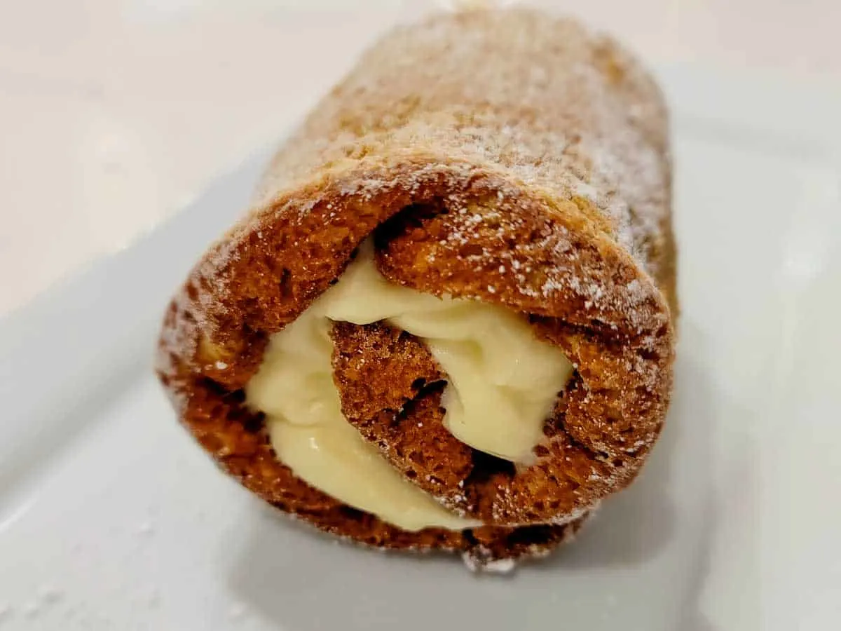 a classic pumpkin roll filled with cream cheese filling on a plate.