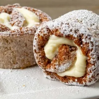 two slices of pumpkin roll cake sprinkled with powdered sugar on a plate.