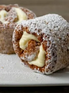 two slices of classic pumpkin roll on a plate.