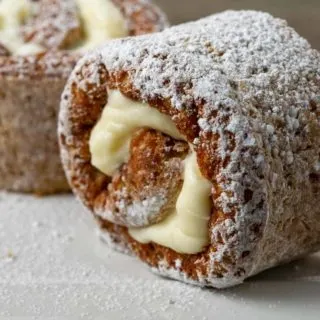 two slices of classic pumpkin roll on a plate.