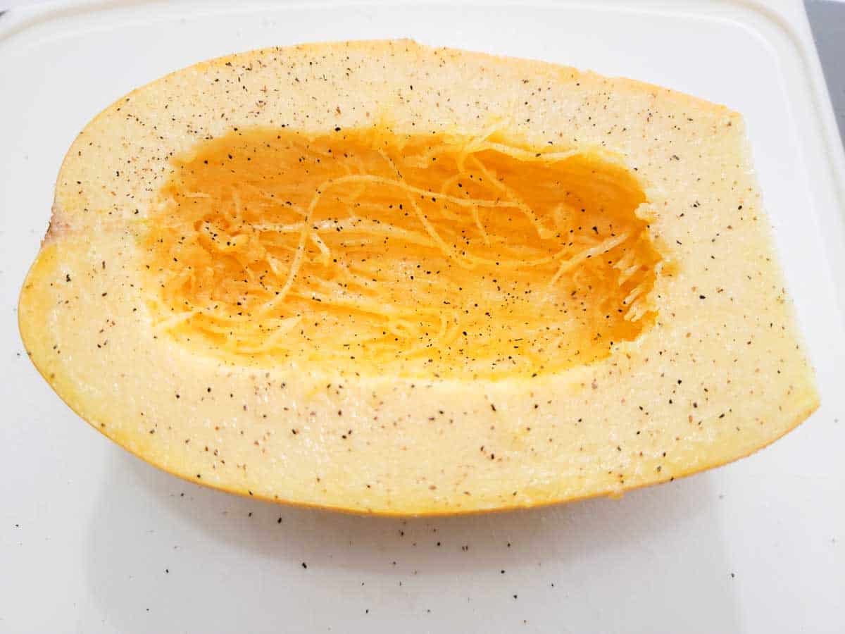 a spaghetti squash half sprinkled with salt and pepper.