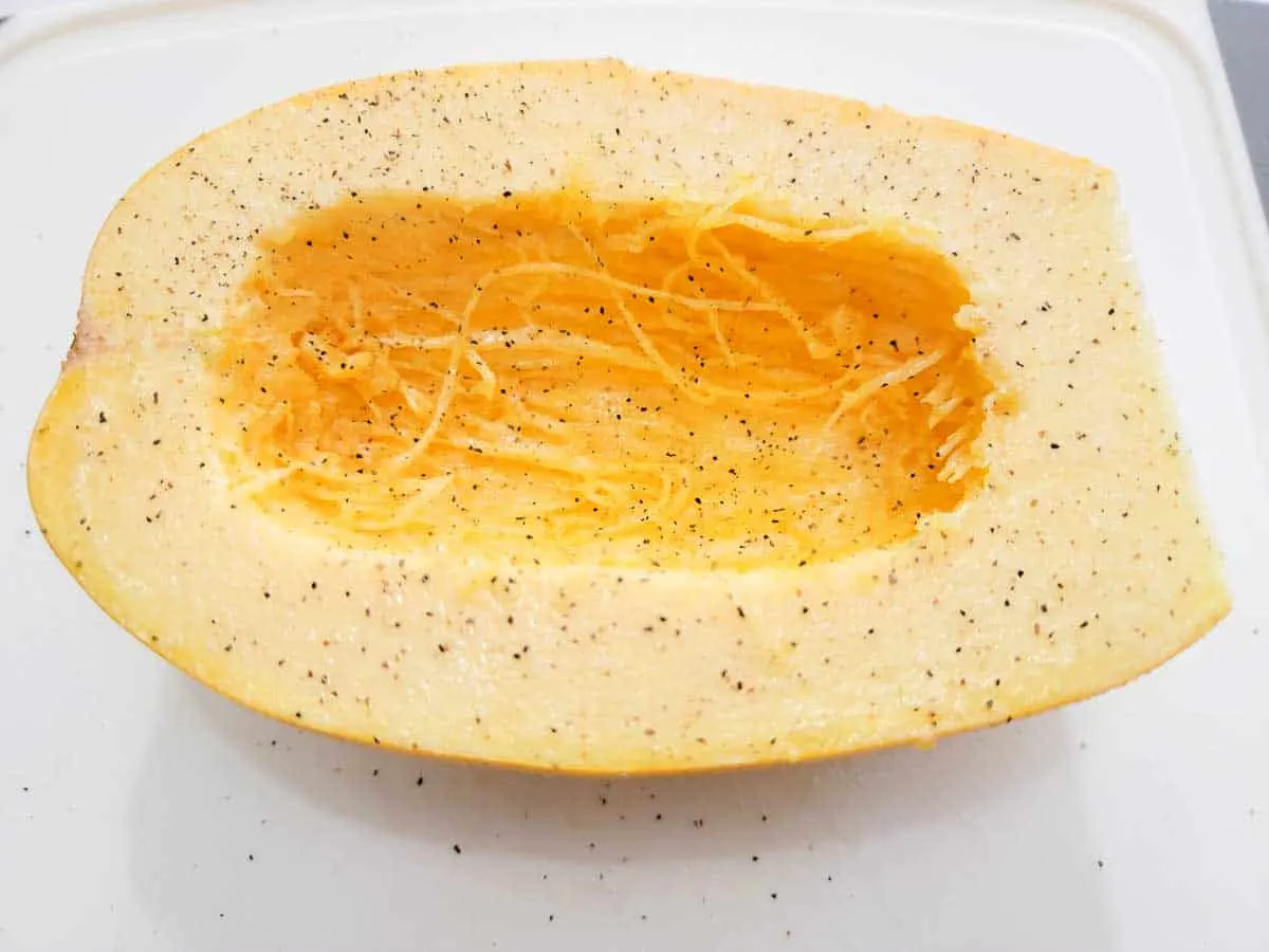 a spaghetti squash half sprinkled with salt and pepper.