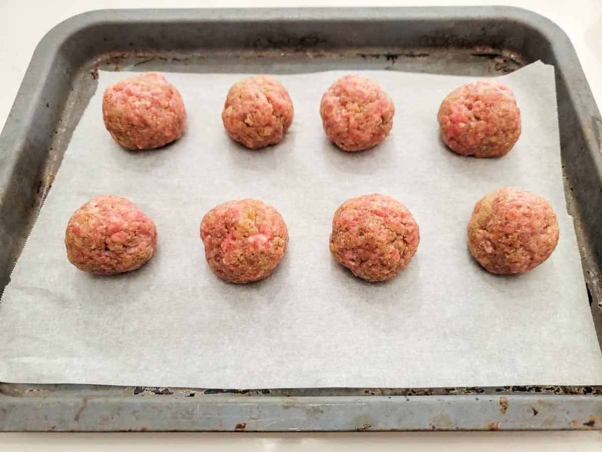 8 meatballs on a baking sheet.