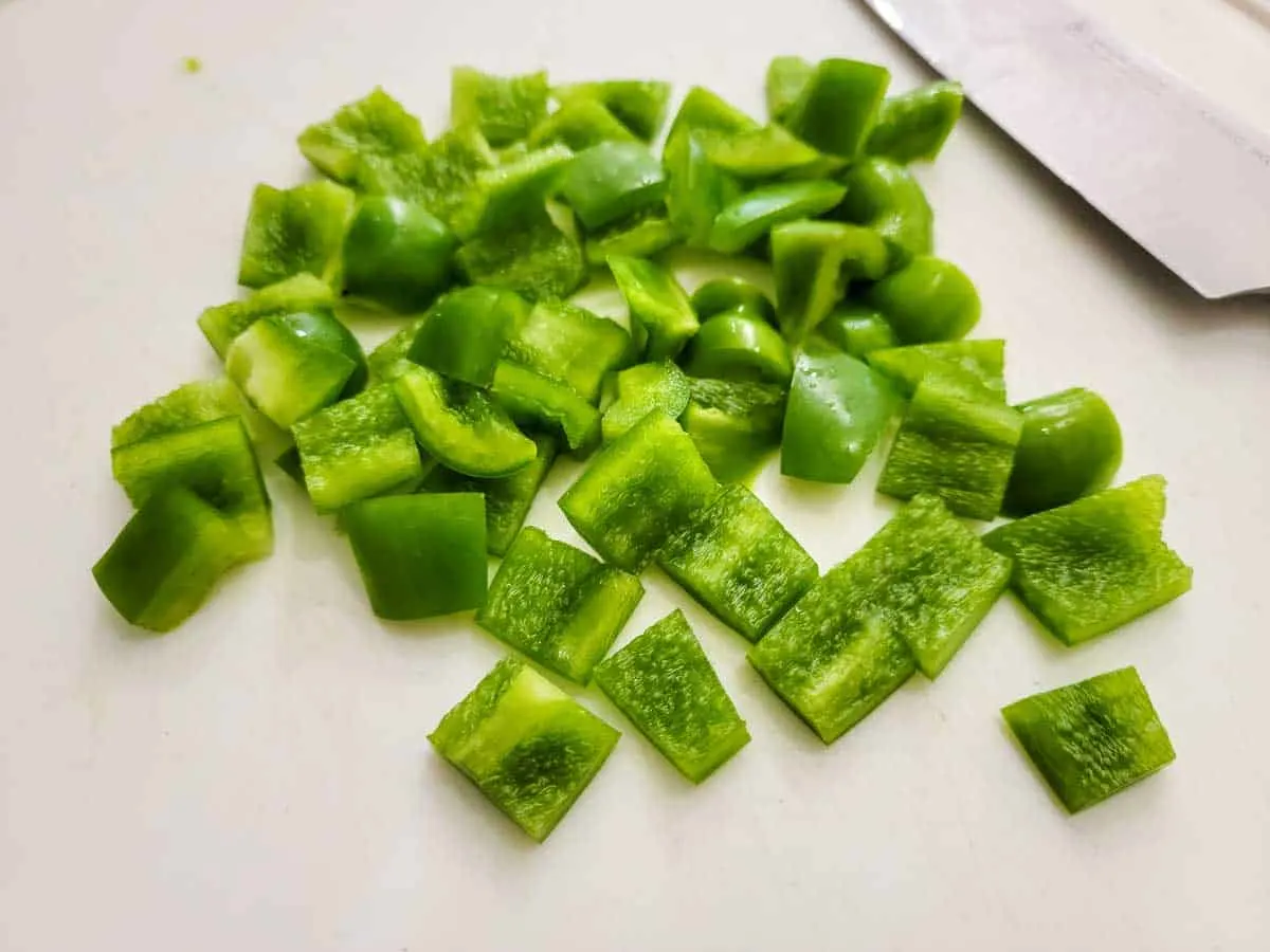green peppers diced on a cutting board.