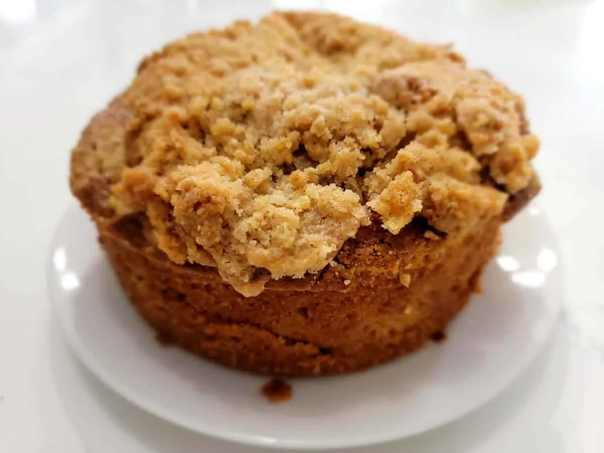 a pumpkin spice coffee cake cooling on a plate.