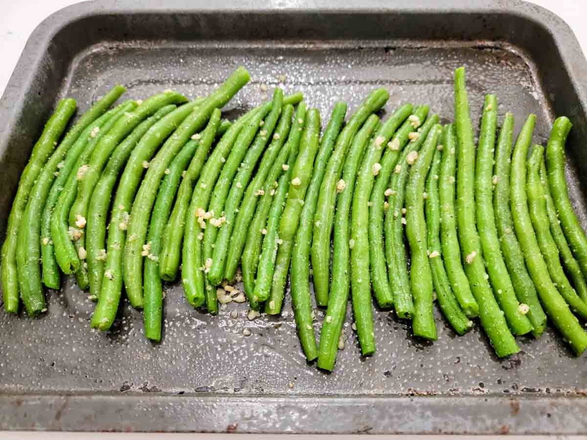 green beans in a row on a baking sheet.