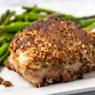 a Pecan Pork Chop and asparagus on a plate.