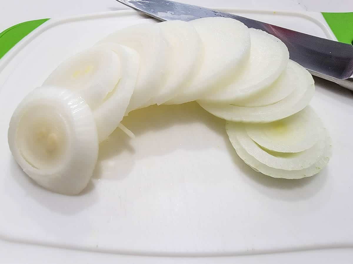 an onion sliced on a cutting board.