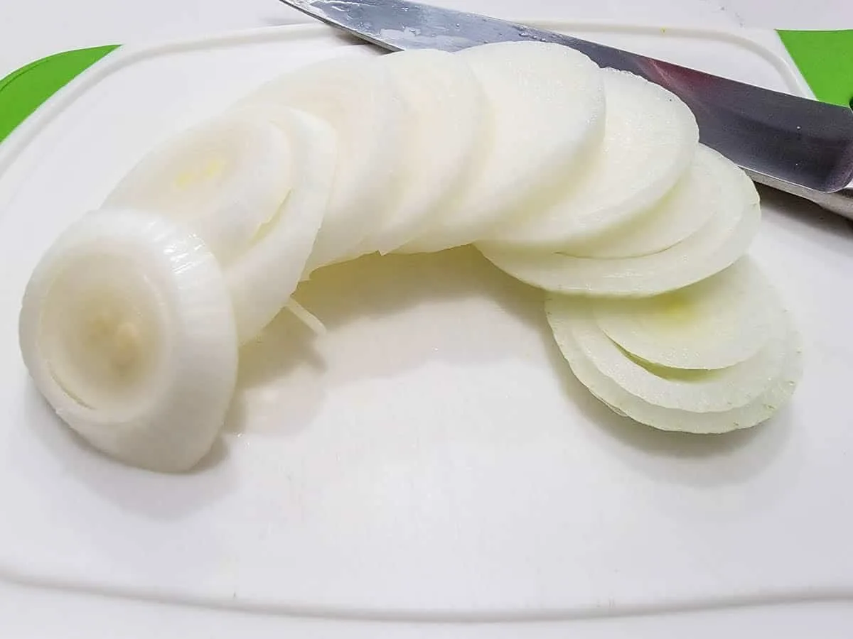 an onion sliced on a cutting board.