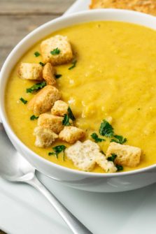 a bowl filled with Pumpkin and Ginger Soup and croutons.