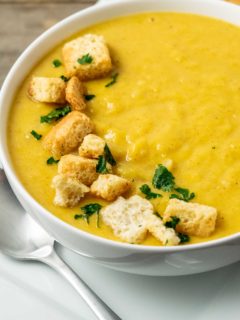 a bowl filled with Pumpkin and Ginger Soup and croutons.