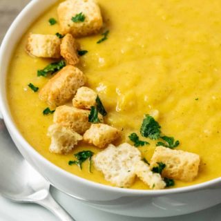 a bowl filled with Pumpkin and Ginger Soup and croutons.