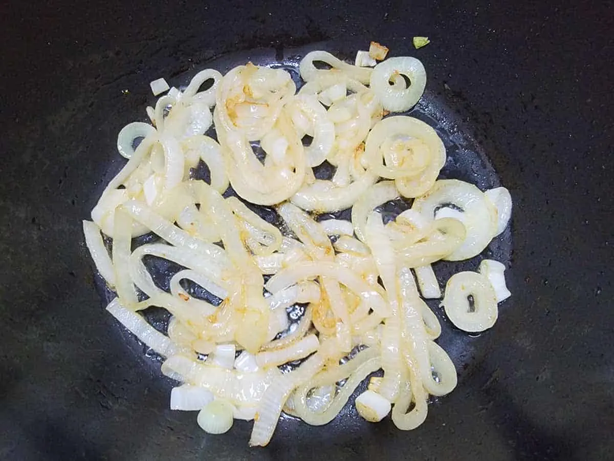 onion slices frying in a pan.