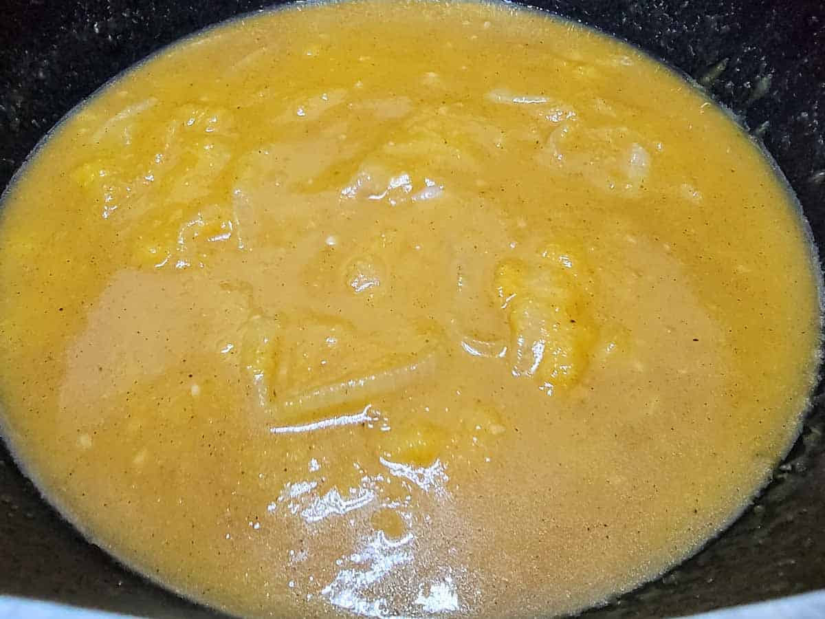 onions, seasonings, pumpkin puree and chicken stock cooking in a pan.