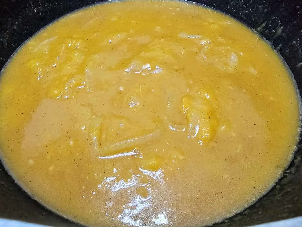 onions, seasonings, pumpkin puree and chicken stock cooking in a pan.