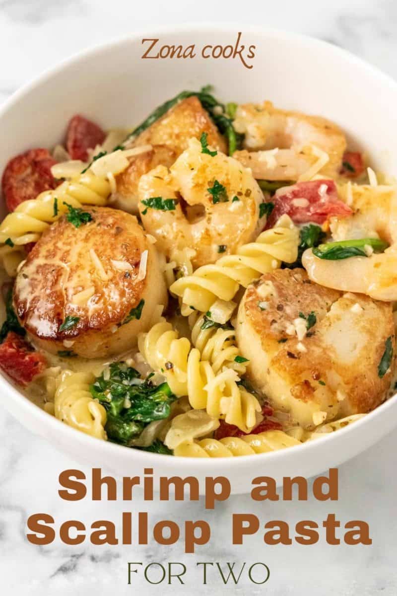 Shrimp and Scallop Pasta with spinach and fire roasted red peppers in a bowl.