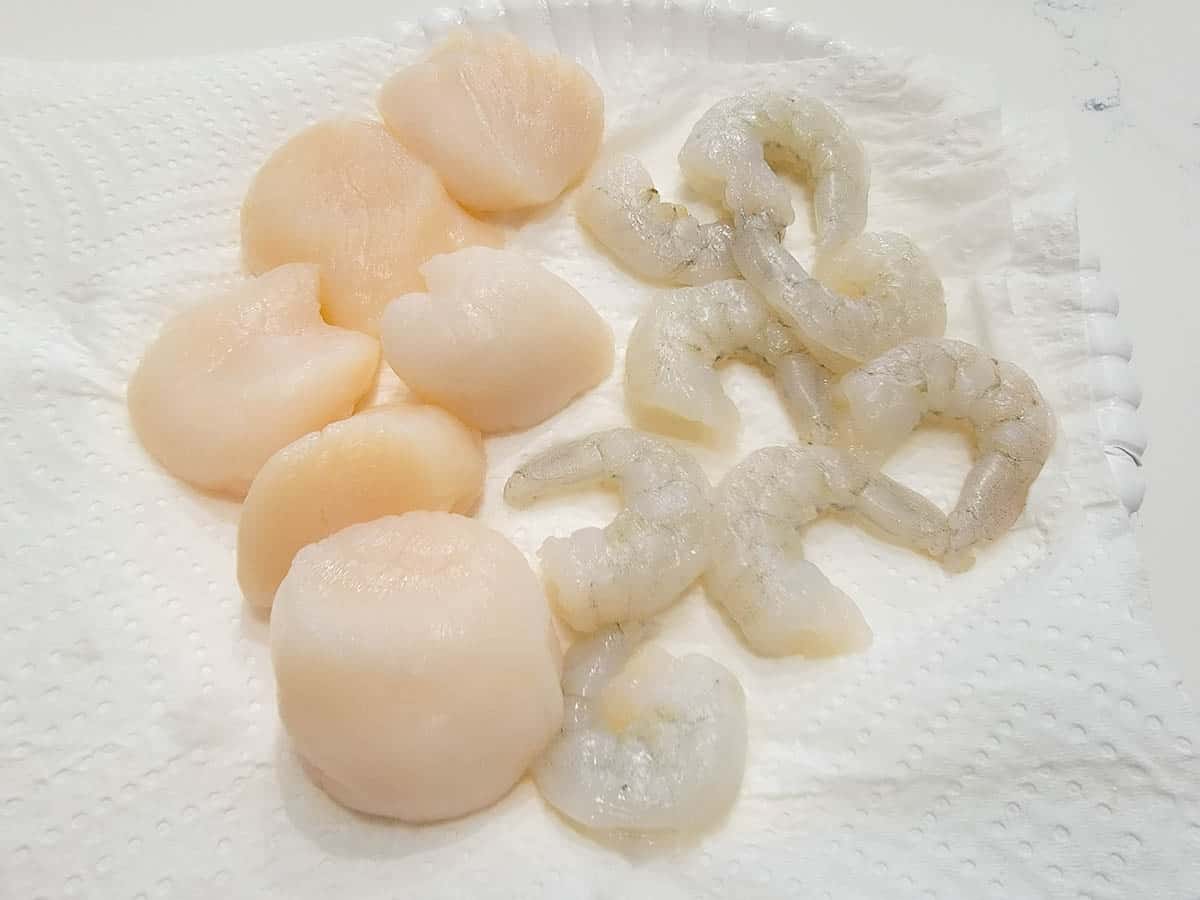 raw scallops and shrimp on paper towel.