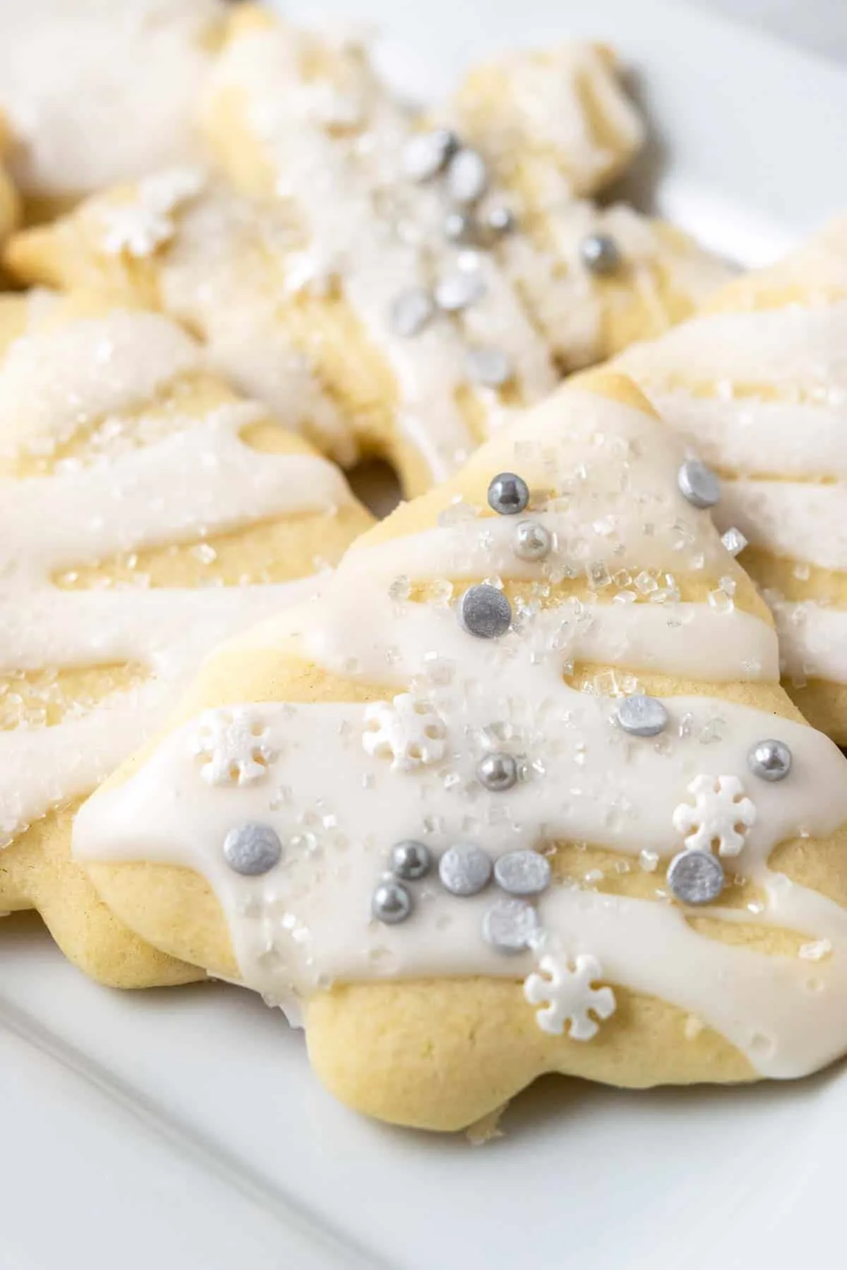 small batch of sugar cookies with icing and sprinkles on a tray.