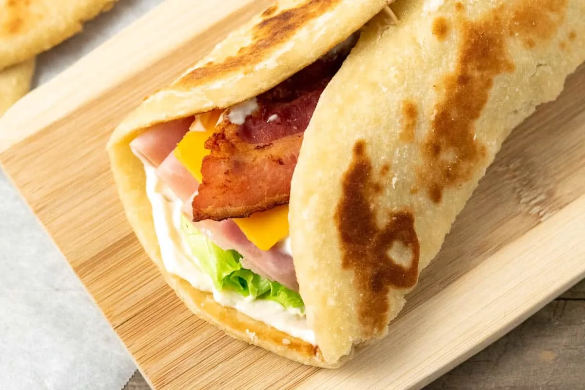 a flatbread sandwich on a cutting board.