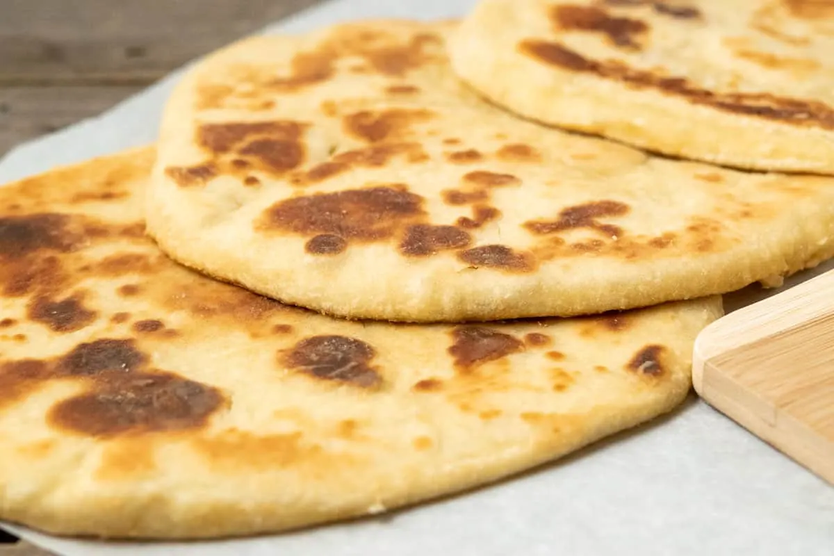 3 large flatbreads on parchment paper.