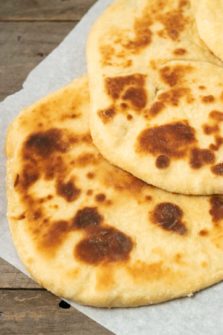 two large flatbreads on parchment paper.