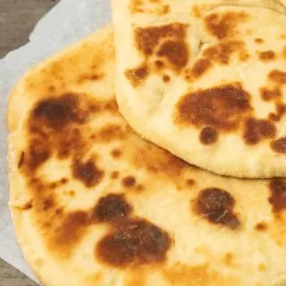 two large flatbreads on parchment paper.