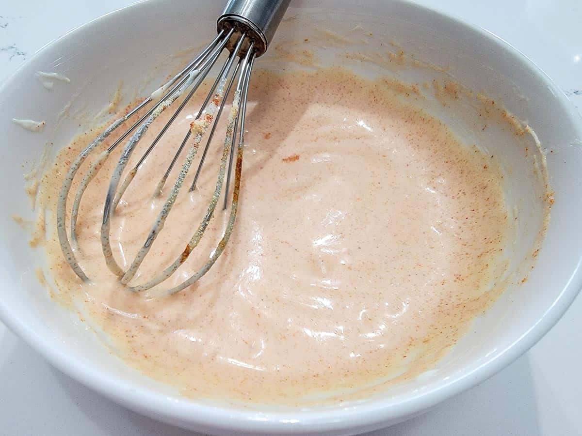 a bowl of yum yum sauce with a whisk in it.