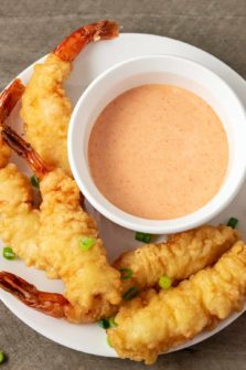 a bowl of homemade yum yum sauce on a plate with shrimp tempura.