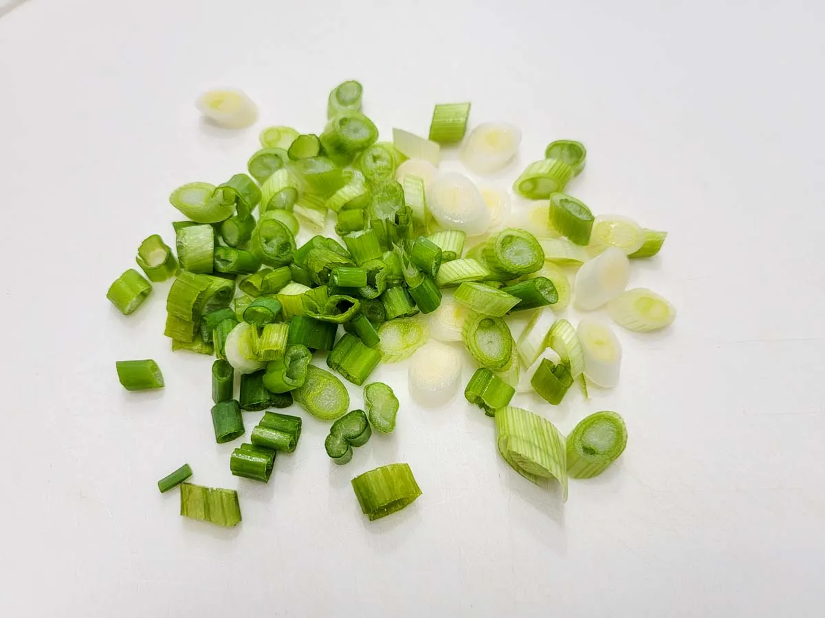 green onions diced on a cutting board.