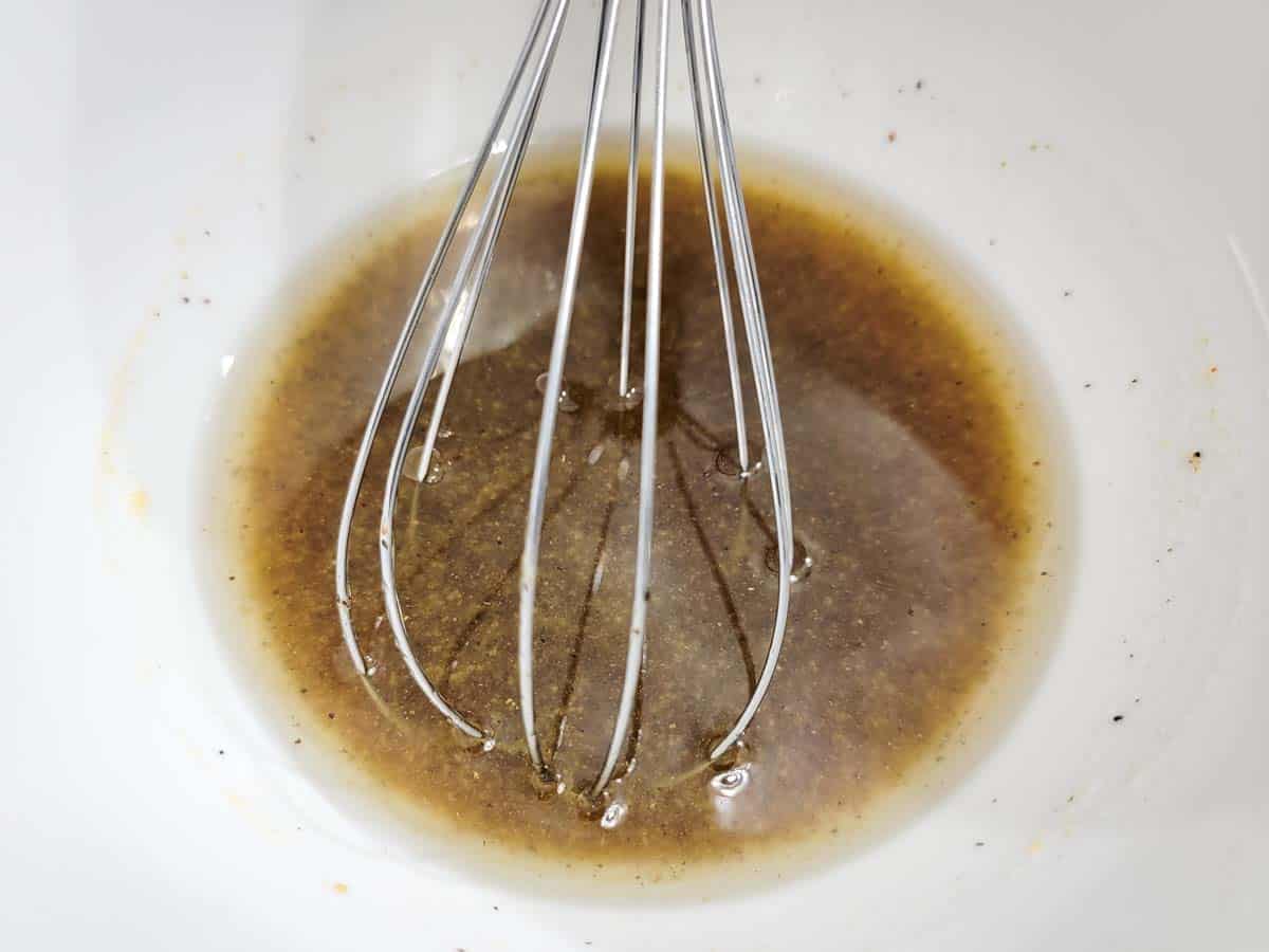 dressing mixed in a bowl with a whisk.