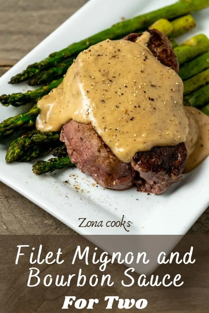 a Filet Mignon topped with Bourbon Sauce over asparagus on a plate.